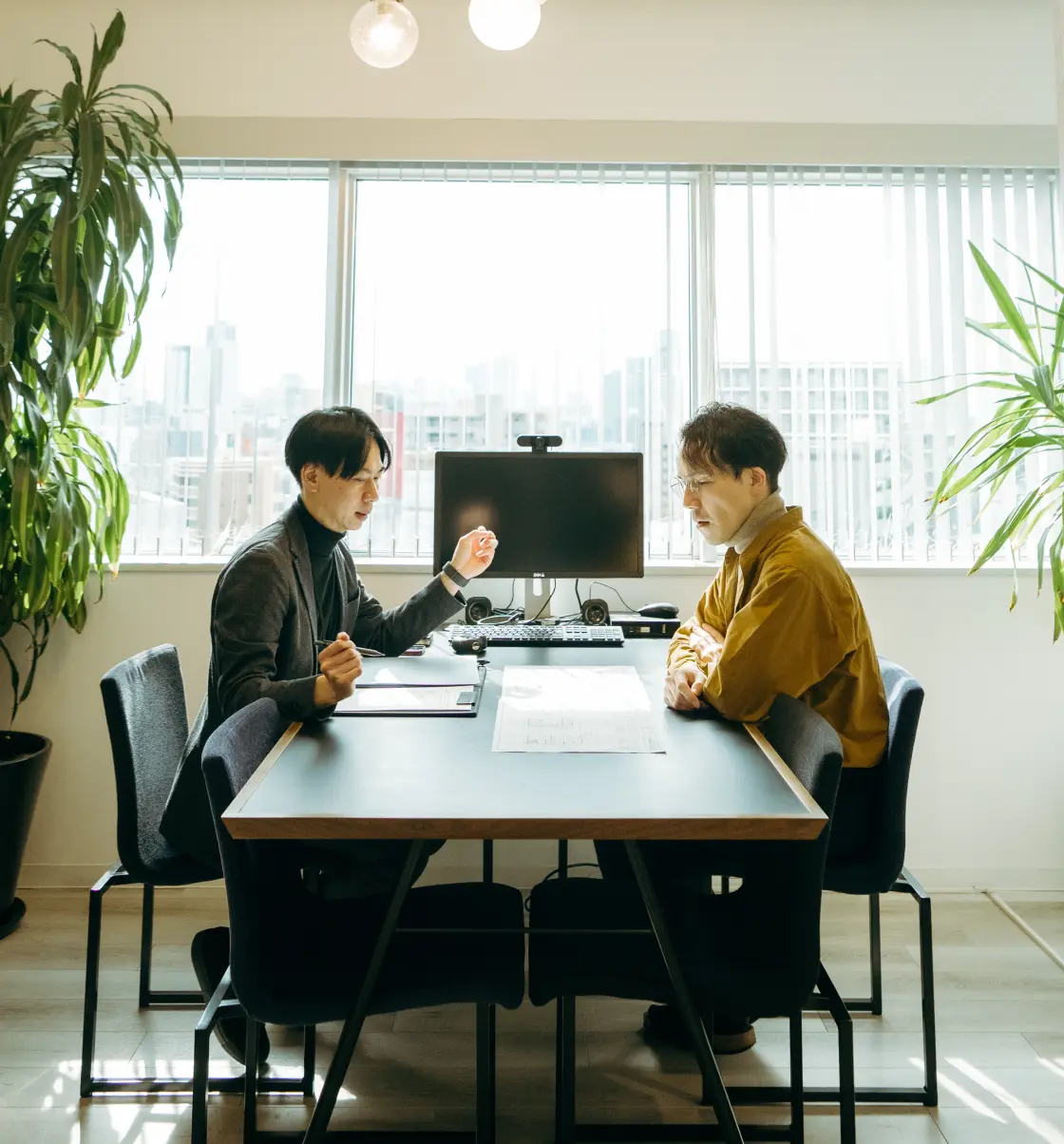 同僚に設計について相談している様子