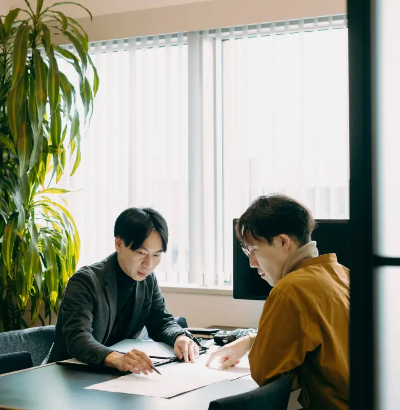 同僚に設計について相談している様子
