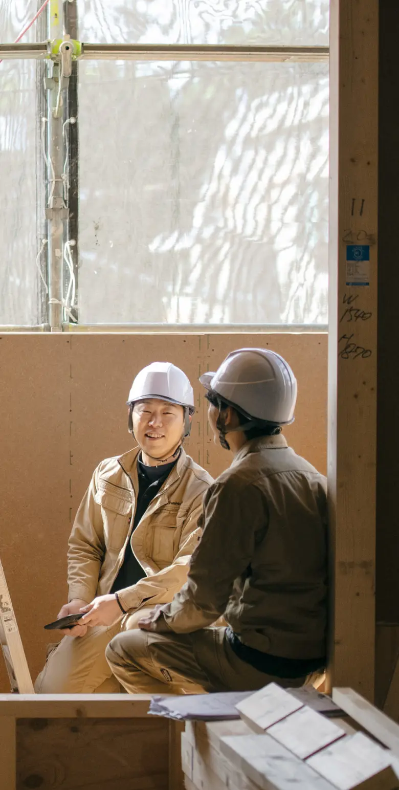 建築現場で打ち合わせを行う施工管理部門の社員
